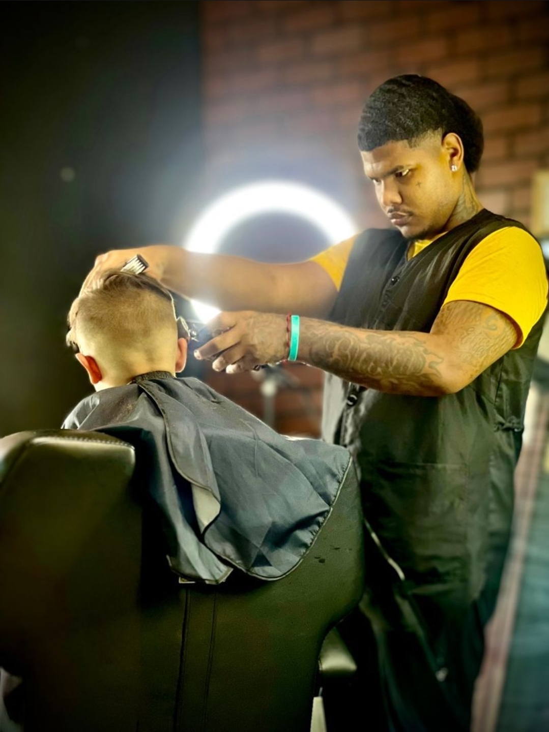 Kaleb cutting hair, showcasing his professional barbering skills and attention to detail